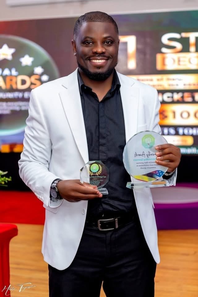 Alex Ahabwe holding awards at a professional recognition event
