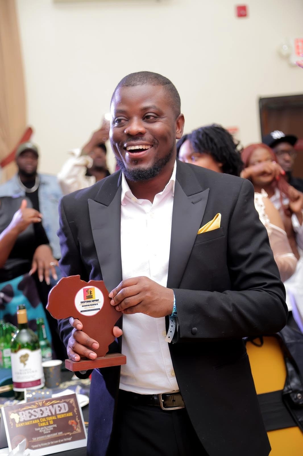 Alex Ahabwe receiving an Award of Excellence for community support
